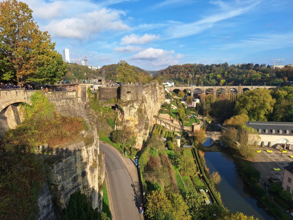 Wer in Luxemburg-Stadt zu Fuß zu Gast ist, sollte natürlich immer auch einen Spaziergang zur Corniche unternehmen. Unten fließt die Alzette und hinter der Eisenbahnbrücke befindet sich das Geburtshaus Robert Schumans. Links zeichnen sich einige Hochhäuser des Europaviertels auf dem Plateau Kirchberg ab.